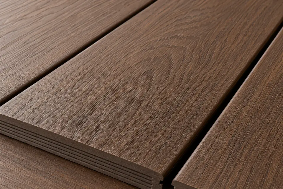 Composite Decking Close-Up | Music City Deck & Fence A close-up of walnut-brown composite deck boards with embossed wood grain and a clean hidden-fastener gap